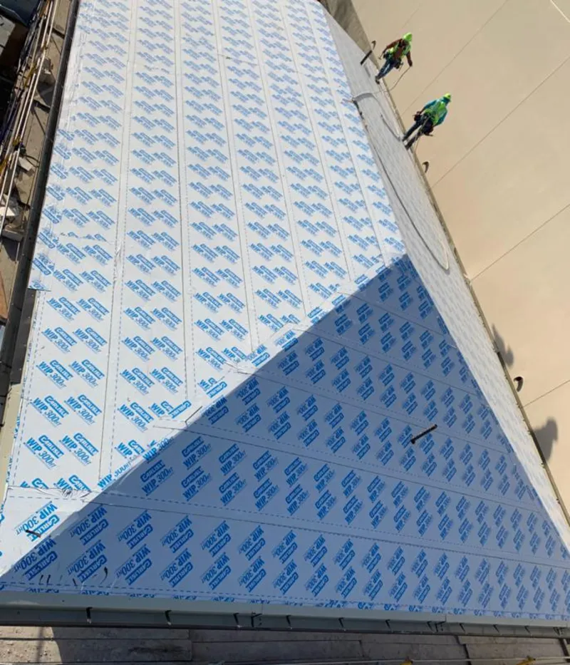 Professional roofers installing underlayment on a metal roof in Medway